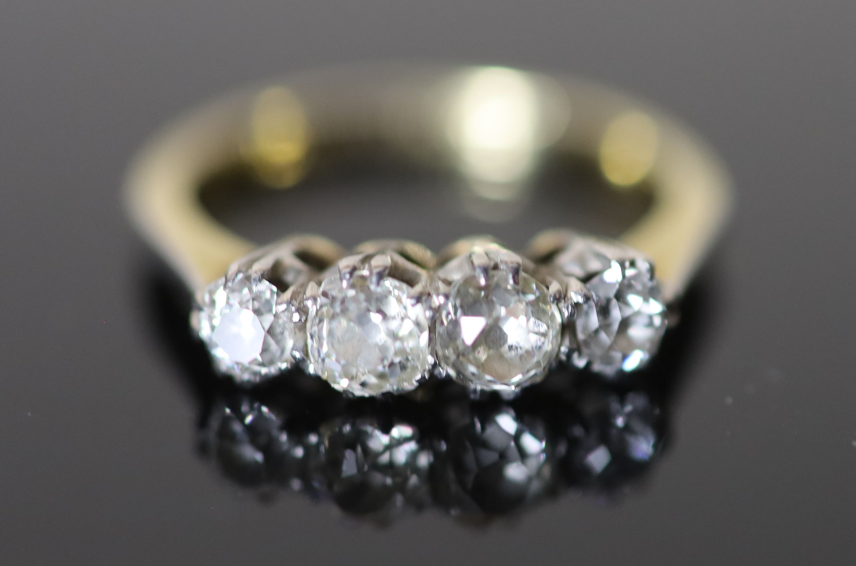 An early 20th century 18ct gold, platinum and graduated four stone diamond ring,